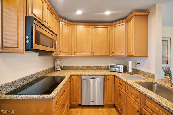 a kitchen with granite countertop a sink a stove and cabinets