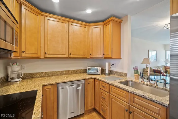 a kitchen with stainless steel appliances granite countertop a sink and cabinets