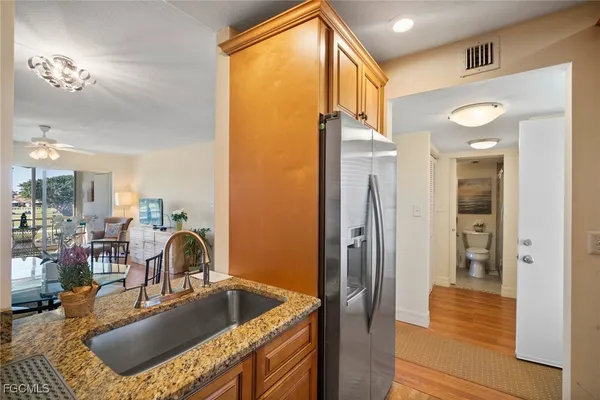 a kitchen with kitchen island a counter top space a sink a refrigerator and a window