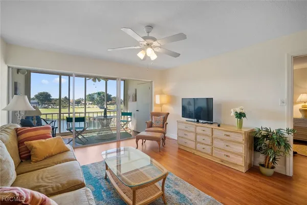 a living room with furniture a flat screen tv and a large window