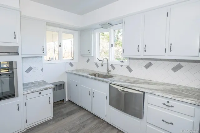 a kitchen with stainless steel appliances white cabinets and a sink