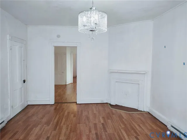 a view of empty room with wooden floor and ceiling fan