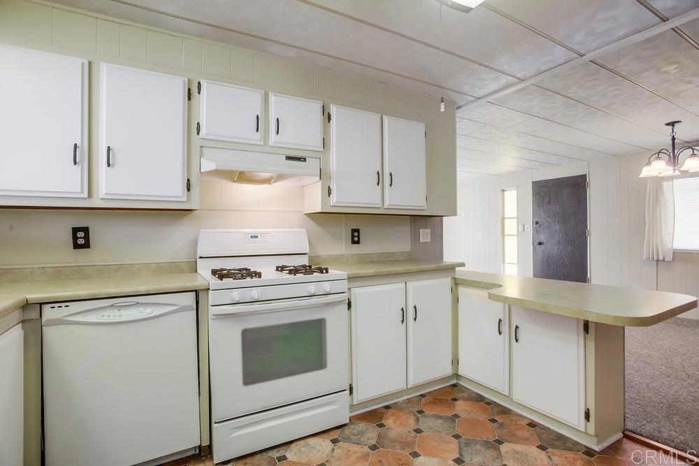 1506 Oak Drive, Unit 22 Vista, CA 92084 - Photo 18 of 58 a kitchen with granite countertop white cabinets and white appliances