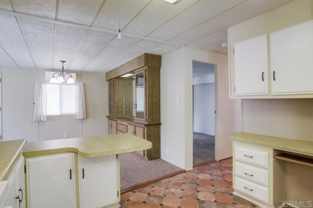 1506 Oak Drive, Unit 22 Vista, CA 92084 - Photo 19 of 58 a kitchen with a sink a refrigerator and chandelier