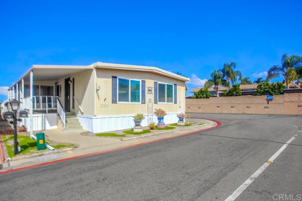 1506 Oak Drive, Unit 22 Vista, CA 92084 - Photo 3 of 58 a front view of a house with a yard and potted plants