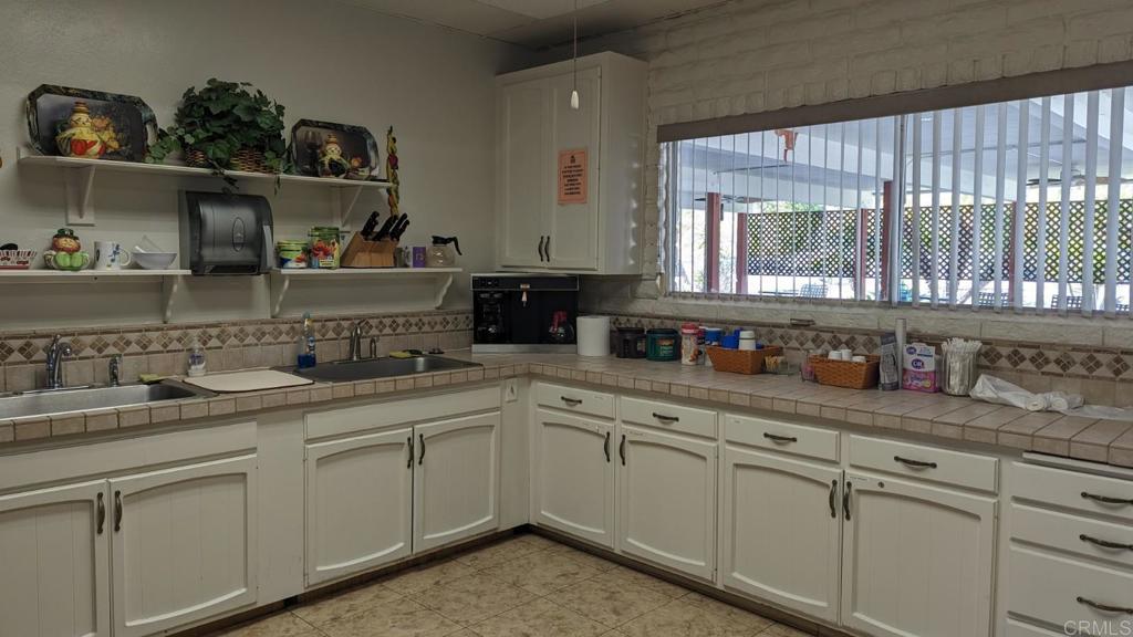 1506 Oak Drive, Unit 22 Vista, CA 92084 - Photo 50 of 58 a kitchen with white cabinets and sink