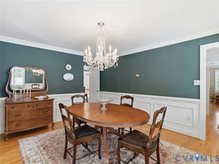 a dining room with furniture a chandelier and window