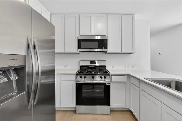 a kitchen with stainless steel appliances a stove a microwave and a refrigerator