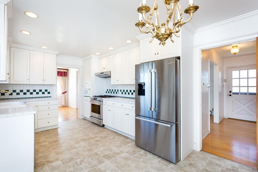 323 Hill Drive Vista, CA 92083 - Photo 13 of 39 a kitchen with stainless steel appliances a refrigerator sink and cabinets