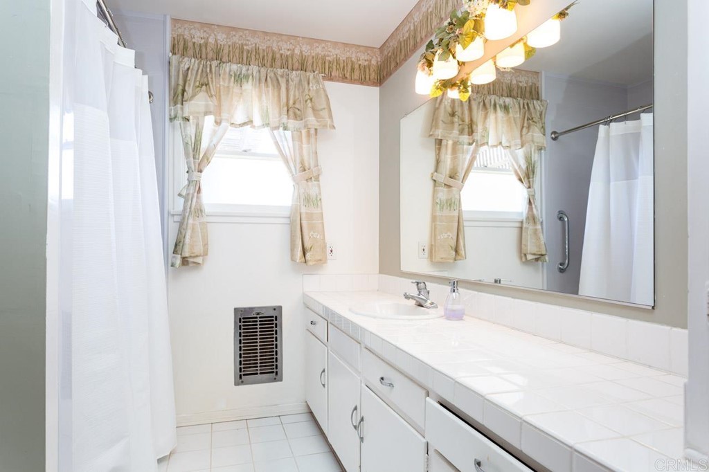 323 Hill Drive Vista, CA 92083 - Photo 15 of 39 a bathroom with a double vanity sink and a mirror