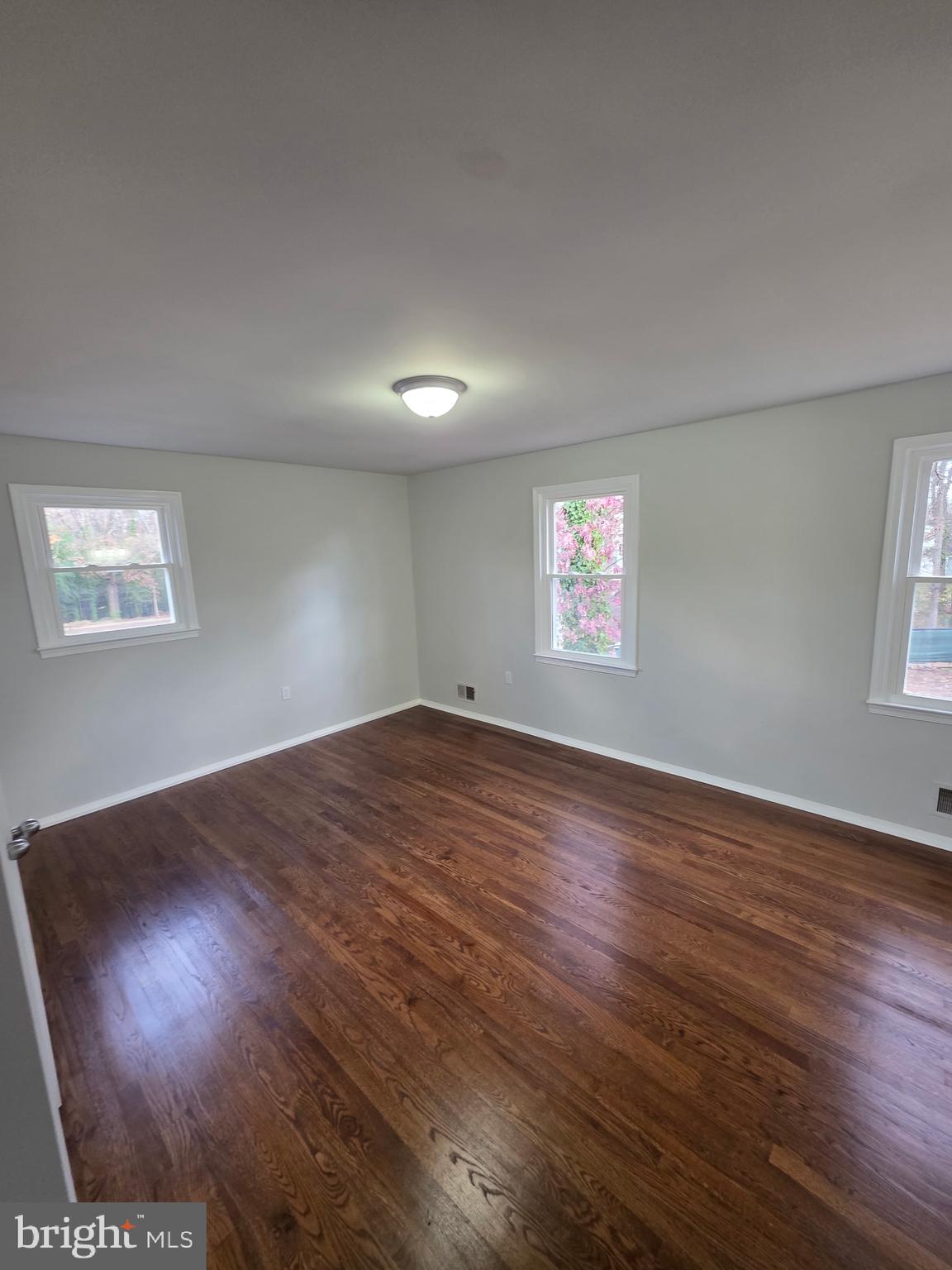 7005 Nightingale Terrace Lanham, MD 20706 - Photo 14 of 23 a view of a big room with wooden floor and windows