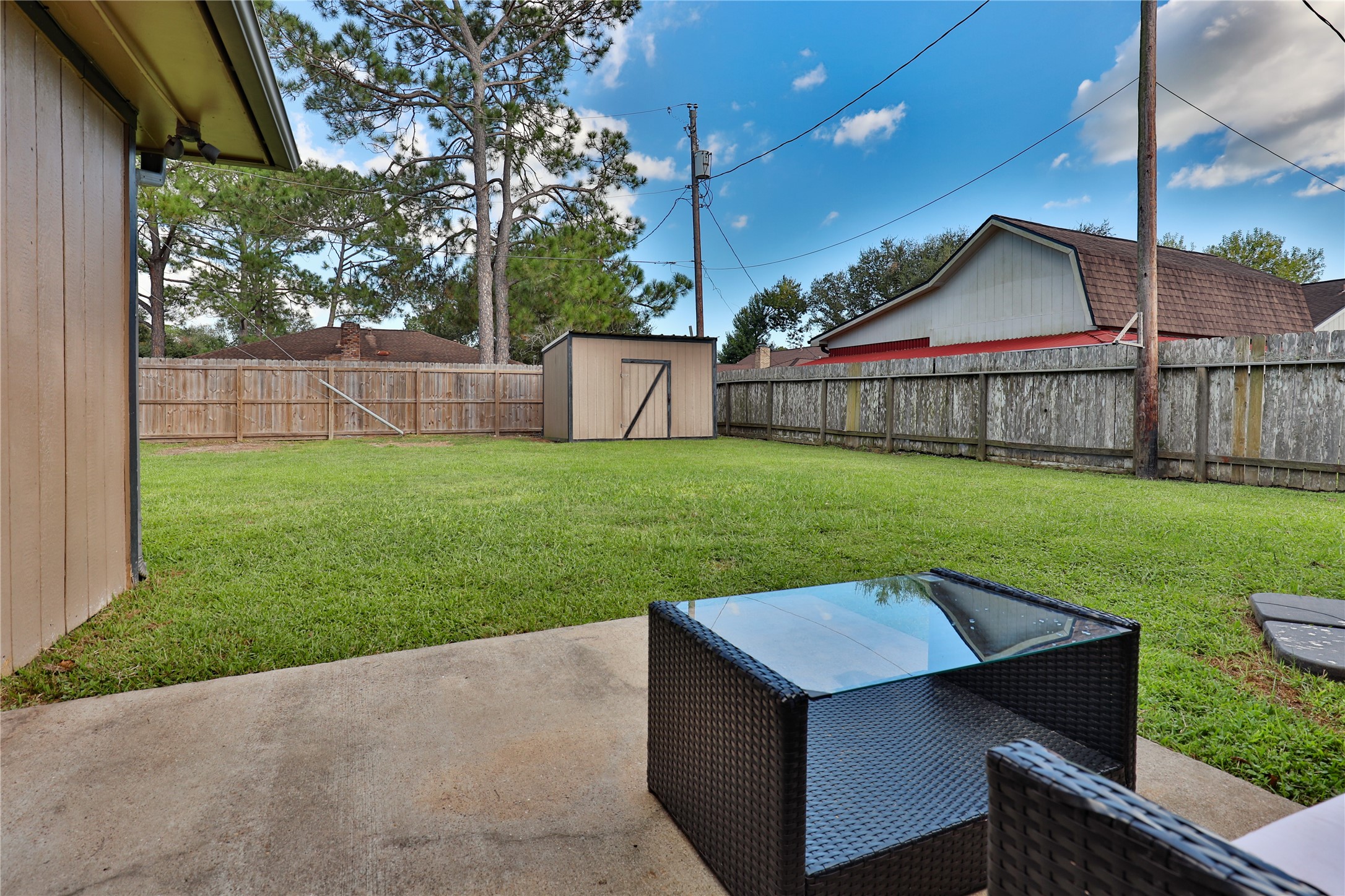 1 Shallowbrook Street Angleton, TX 77515 - Photo 26 of 30 a view of a backyard with a small cabin and wooden fence