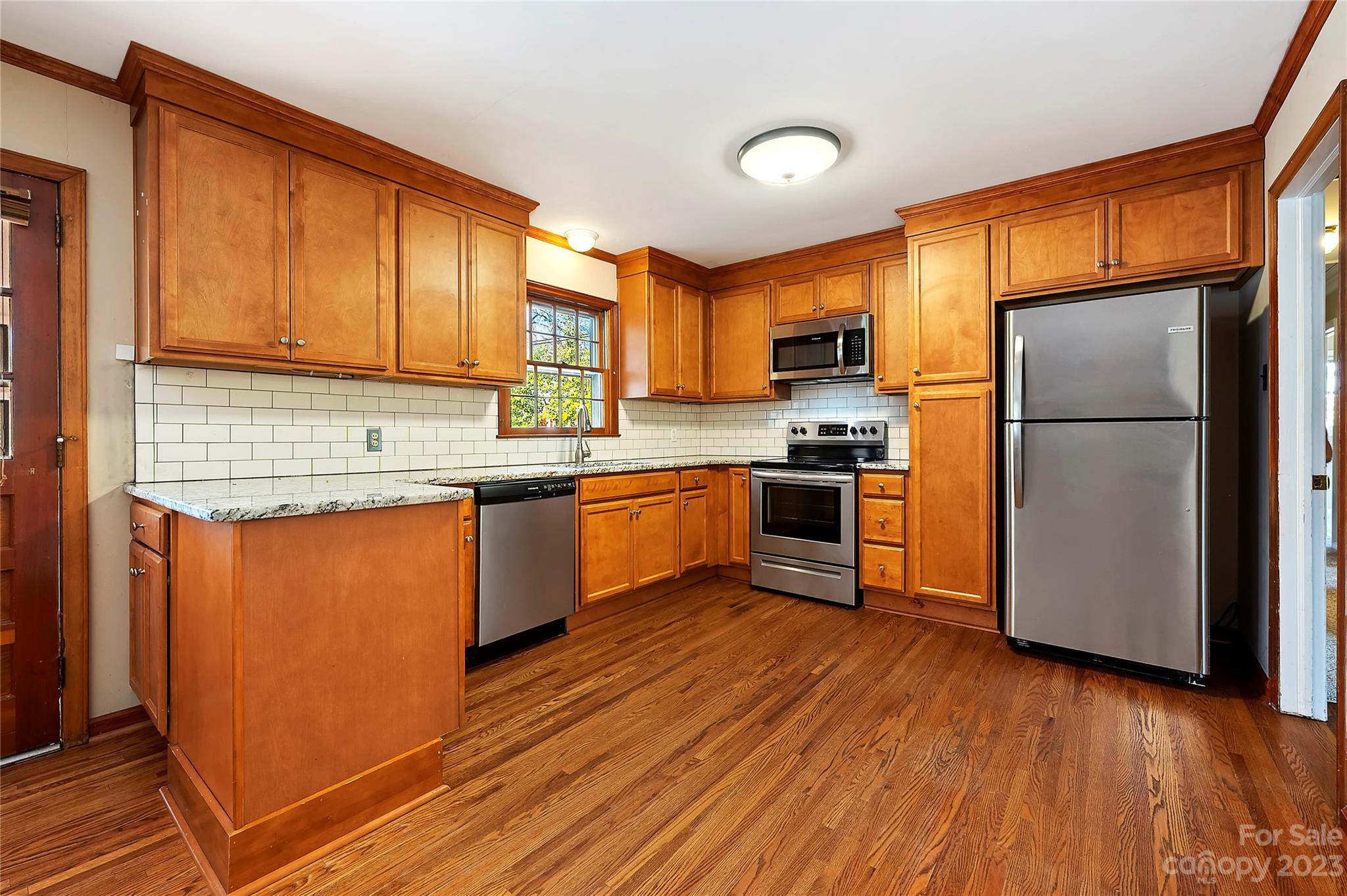 4200 Murrayhill Road Charlotte, NC 28209 - Photo 13 of 29 a kitchen with wooden floors stainless steel appliances a sink and a window