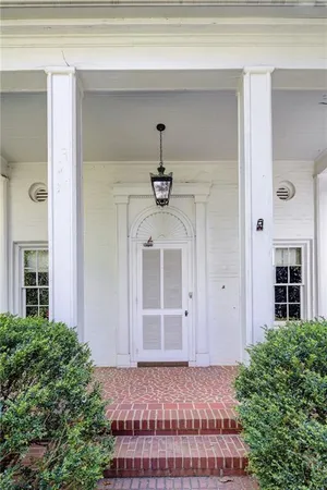 a view of a hallway with windows and chandelier