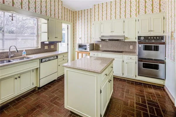 a kitchen with stainless steel appliances a stove sink and cabinets