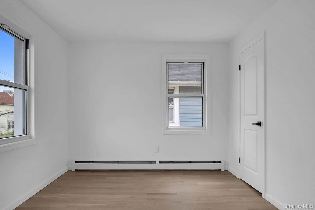 173-62 103rd Road Queens, NY 11433 - Photo 6 of 23 an empty room with a empty space and windows