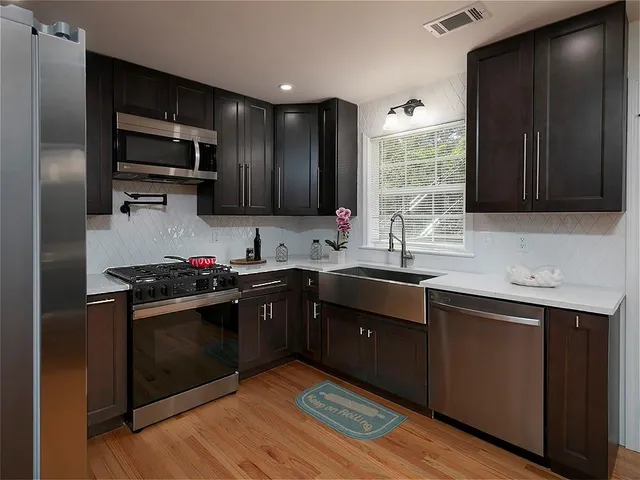 a kitchen with stainless steel appliances granite countertop a stove sink microwave and refrigerator
