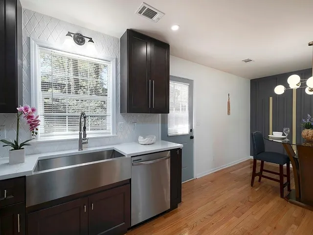 a kitchen with a sink cabinets and wooden floor