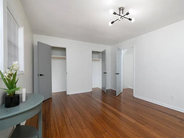 a view of room with hardwood floor and a ceiling fan