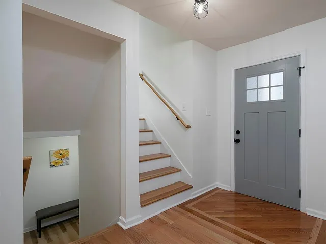 a view of a livingroom with wooden floor and stairs