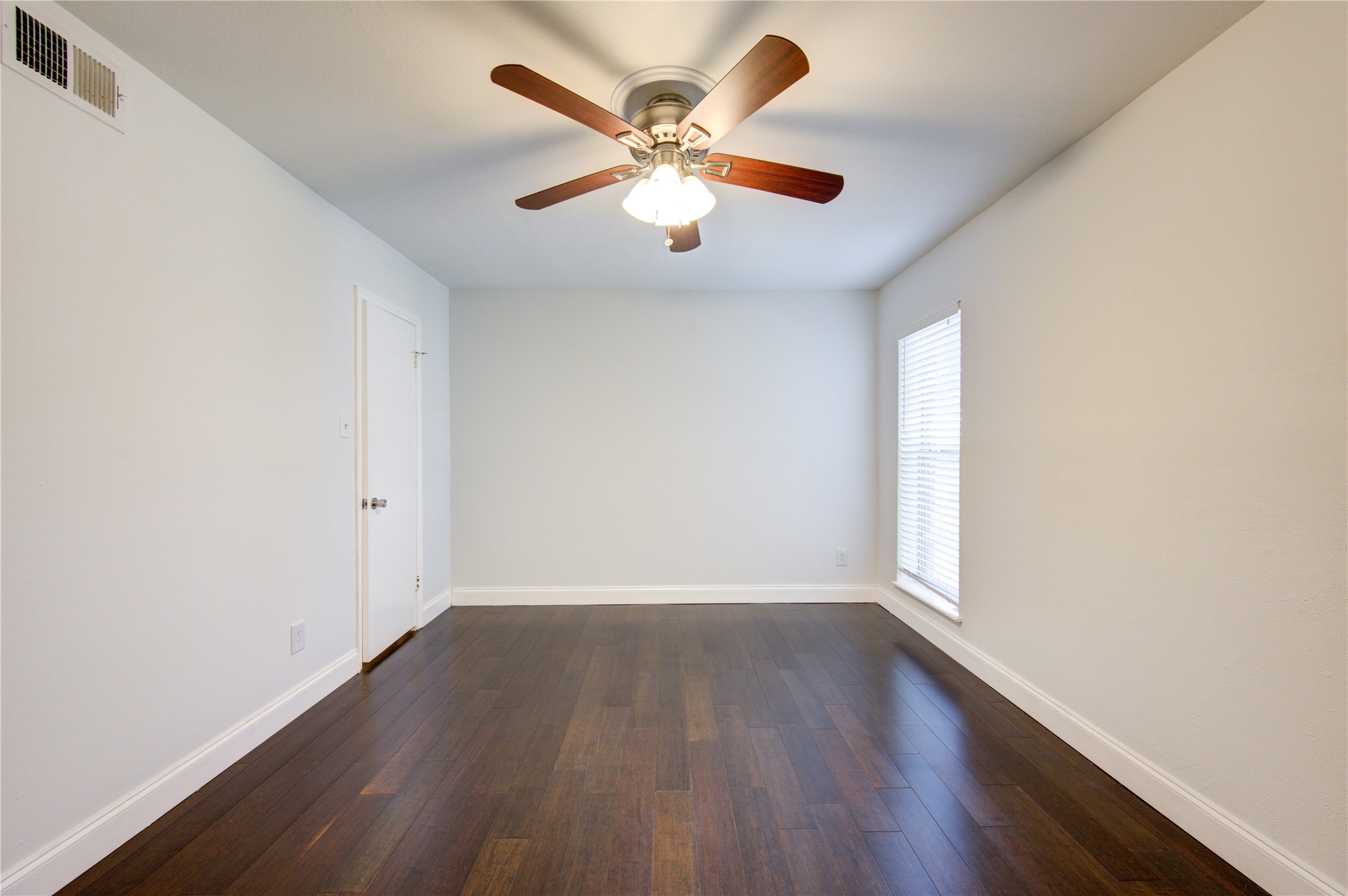 1909 Brun Street, Unit 16 Houston, TX 77019 - Photo 7 of 19 wooden floor in an empty room with a window
