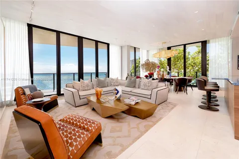 a living room with furniture and large windows