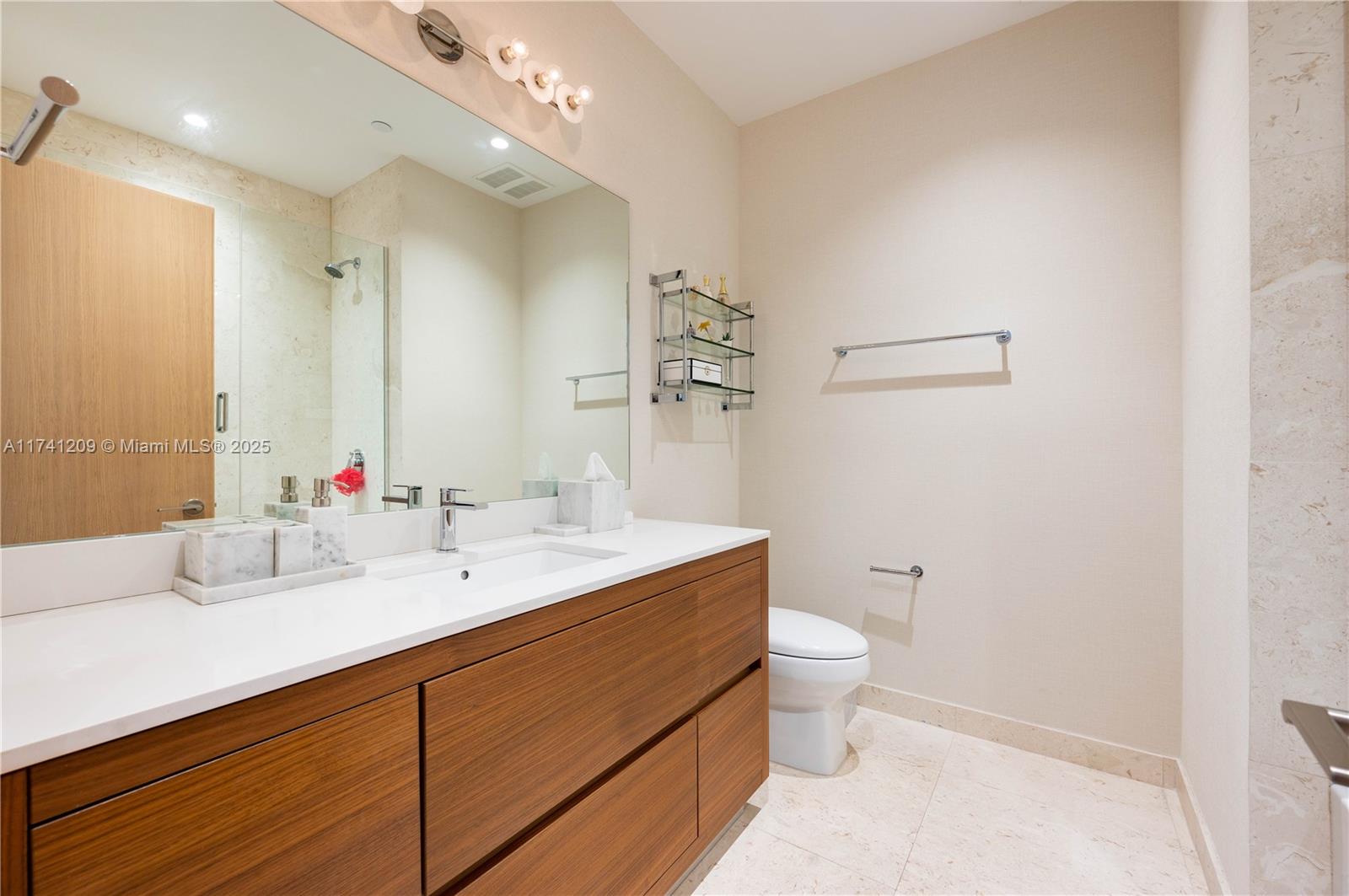 3581 East Glencoe Street, Unit 301 Miami, FL 33133 - Photo 18 of 21 a bathroom with a double vanity sink mirror and toilet