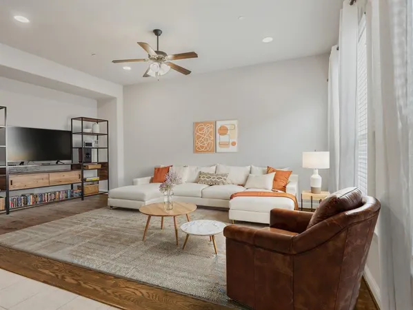 a view of an empty room with wooden floor and a ceiling fan