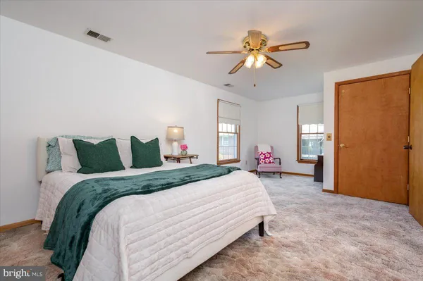 a spacious bedroom with a bed and a chandelier