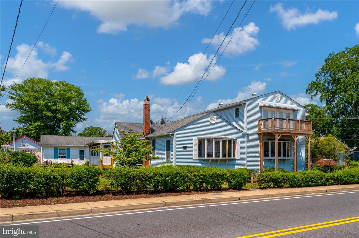 8236 Bayside Road Chesapeake Beach, MD 20732 - Photo 2 of 39 a front view of a house with a yard and garage