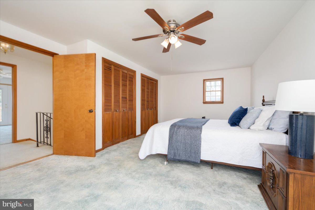 8236 Bayside Road Chesapeake Beach, MD 20732 - Photo 26 of 39 a spacious bedroom with a bed and a chandelier