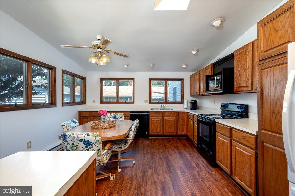 8236 Bayside Road Chesapeake Beach, MD 20732 - Photo 6 of 39 a kitchen with stainless steel appliances granite countertop hardwood floor sink stove dining table and chairs