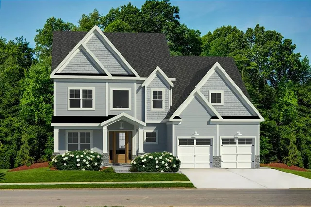 a front view of a house with a garden and trees