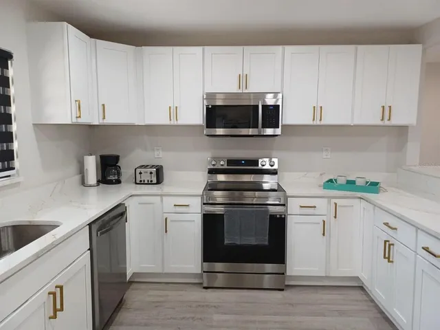 a kitchen with white cabinets and white appliances