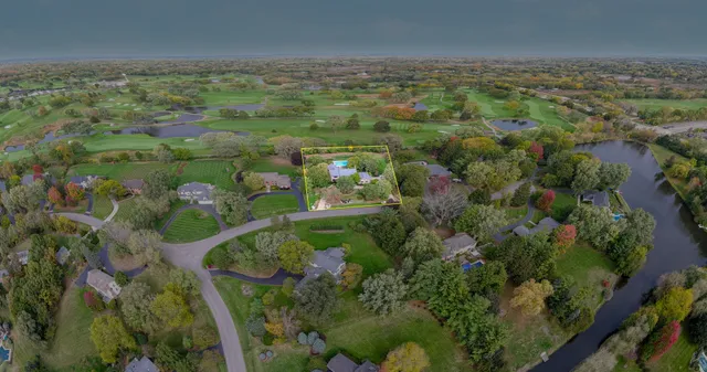 an aerial view of residential houses with outdoor space and trees