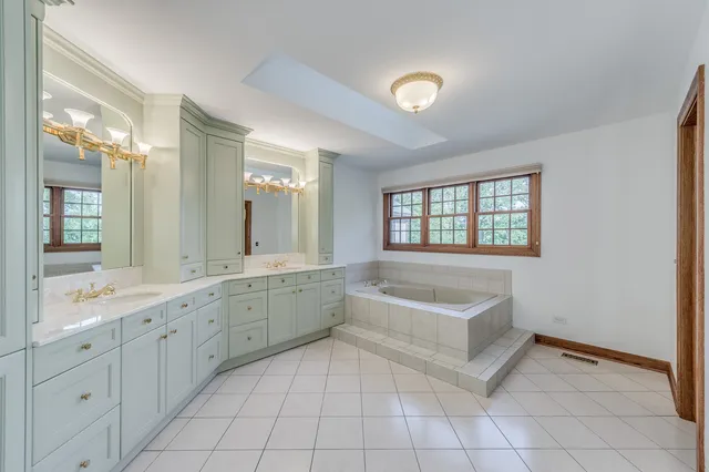 an empty room with ceiling fan and windows