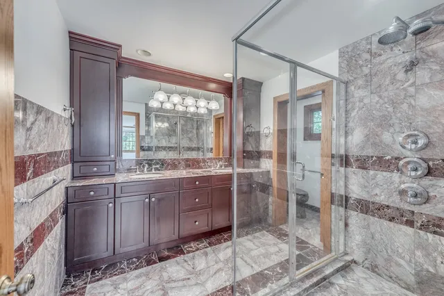 a bathroom with a sink a toilet and shower