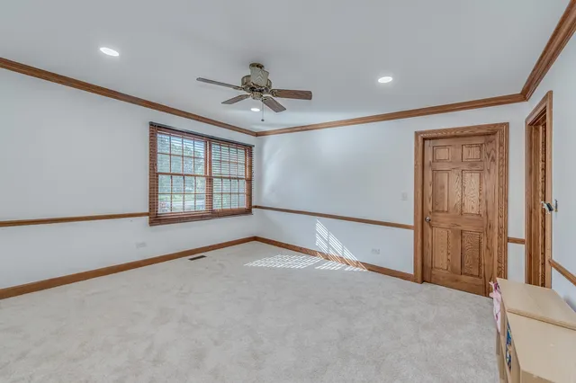 a view of an empty room with wooden floor and closet