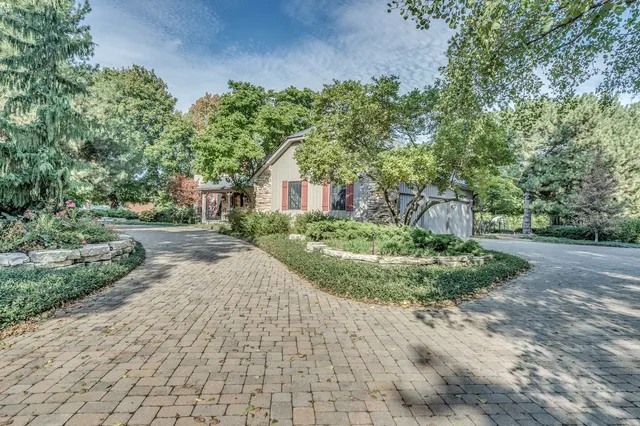 a front view of a house with a yard and potted plants
