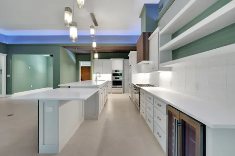 a large white kitchen with lots of counter space and a sink