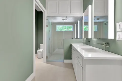 a spacious bathroom with double vanity and a mirror