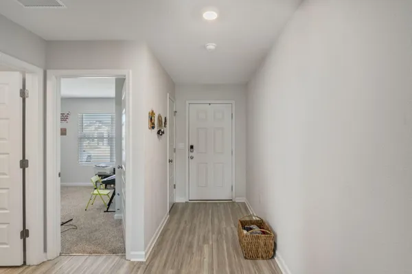 a hallway with sliding door and wooden floor
