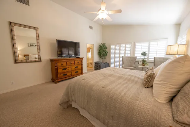 a spacious bedroom with a bed and a flat screen tv
