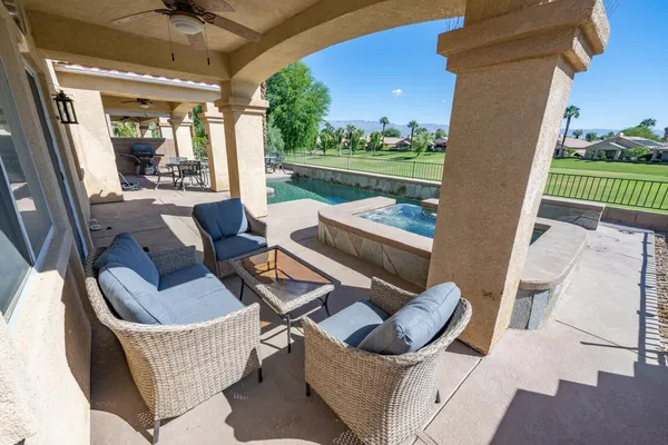 a view of a patio with couches chairs and a floor to ceiling window