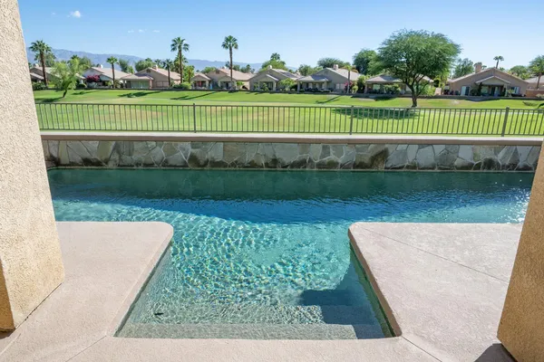a view of a patio with table and chairs potted plants with floor to ceiling window and potted plants