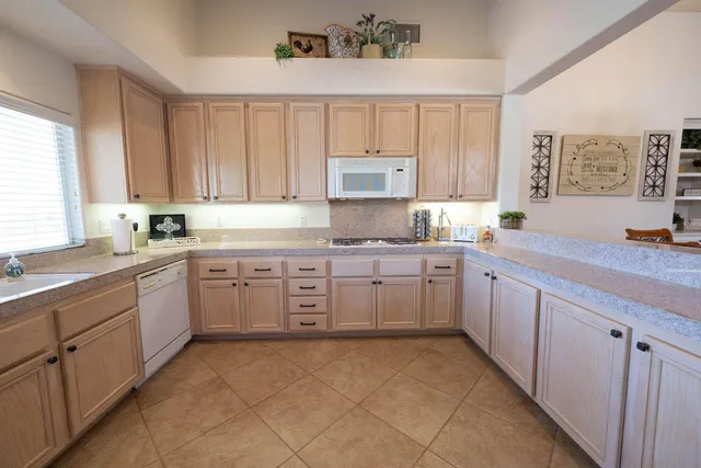 a kitchen with kitchen island granite countertop a sink window and cabinets