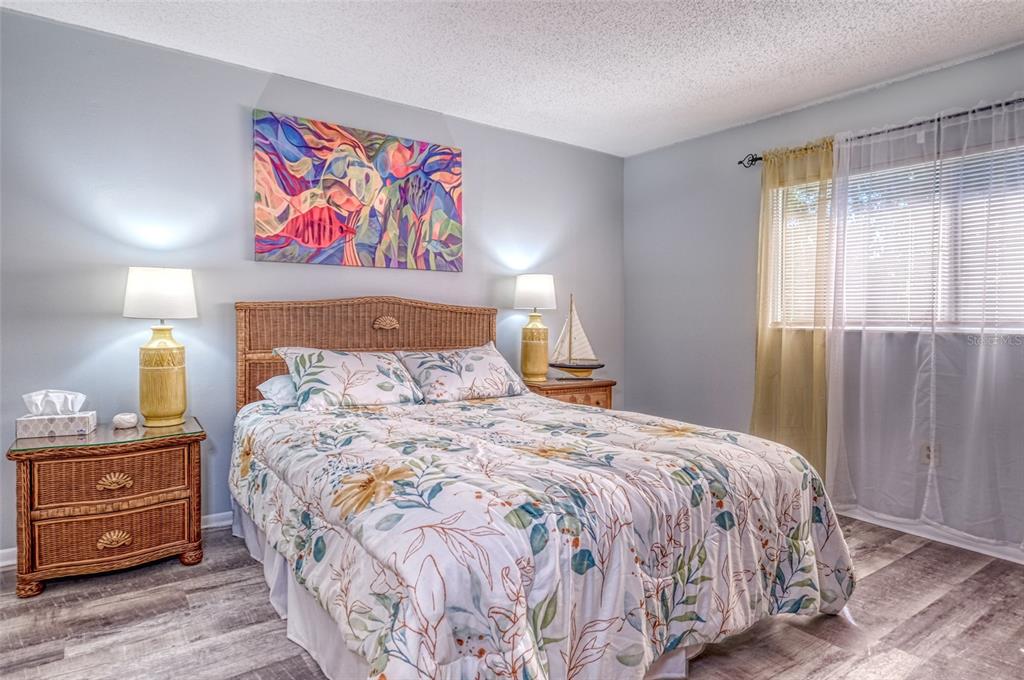 13714 Mission Oaks Boulevard, Unit 13714 Seminole, FL 33776 - Photo 13 of 24 a bedroom with a bed and a painting on the wall