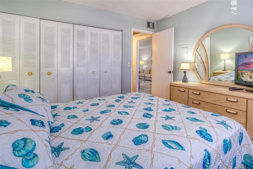 13714 Mission Oaks Boulevard, Unit 13714 Seminole, FL 33776 - Photo 16 of 24 a bedroom with a bed and a dresser in it