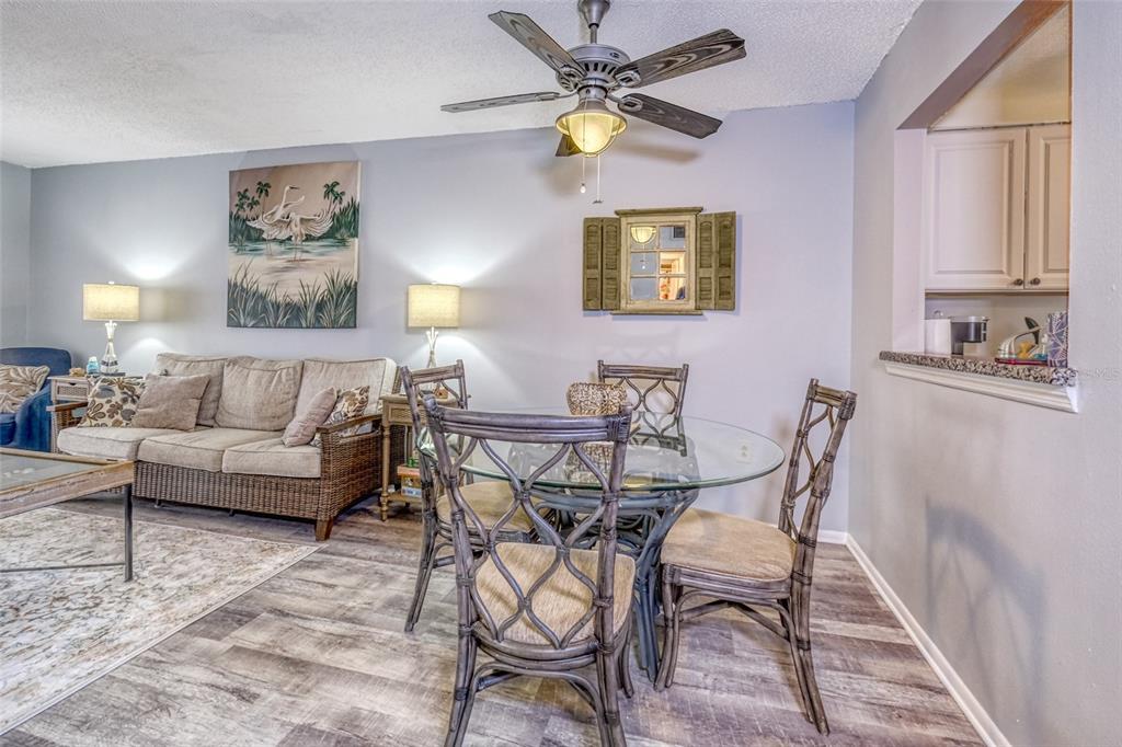 13714 Mission Oaks Boulevard, Unit 13714 Seminole, FL 33776 - Photo 4 of 24 a view of a livingroom and a dining room with wooden floor and a chandelier fan