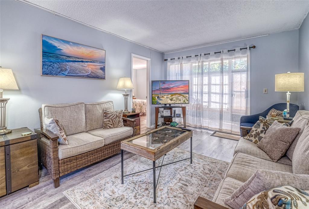 13714 Mission Oaks Boulevard, Unit 13714 Seminole, FL 33776 - Photo 6 of 24 a living room with furniture and a large window